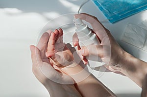 Close-up of adult hands puffs on antiseptics on baby photo